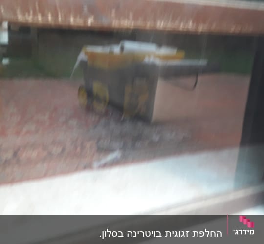 השתקפות של עגלה צהובה על זכוכית חלון